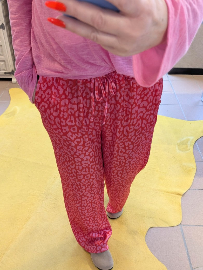 Stilvoll und sinnlich! Die rote Hose aus Satin Viskose mit Leo Muster in Pink ist ein echter Hingucker. Entdecke jetzt einen neuen, aufregenden Stil!