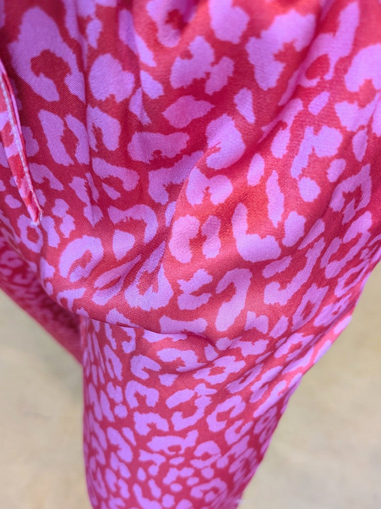 Stilvoll und sinnlich! Die rote Hose aus Satin Viskose mit Leo Muster in Pink ist ein echter Hingucker. Entdecke jetzt einen neuen, aufregenden Stil!