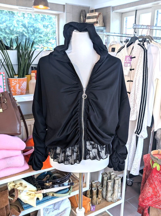 Elegante Jacke aus fließender Viskose in Schwarz mit zartem Spitzensaum, romantischen Rüschenärmeln und praktischer Kapuze - vielseitige Styling-Möglichkeiten.