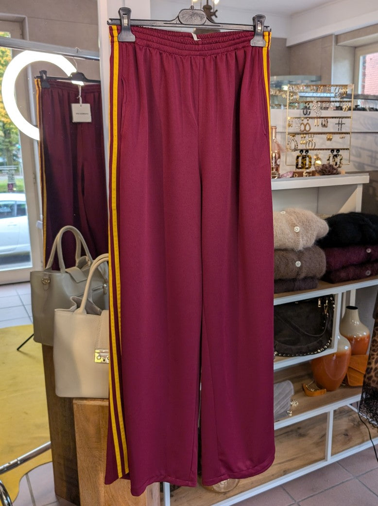 Erlebe Komfort und Style mit der trendigen Jogginghose von CHANCE OFF in Burgund Rot mit den markanten dynamischen drei Streifen in Gelb - für entspannte Tage!