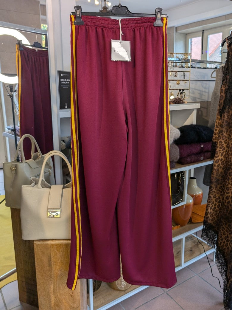 Erlebe Komfort und Style mit der trendigen Jogginghose von CHANCE OFF in Burgund Rot mit den markanten dynamischen drei Streifen in Gelb - für entspannte Tage!