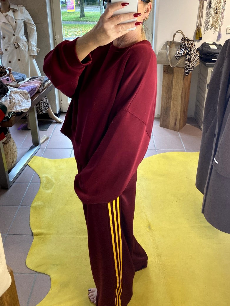 Erlebe Komfort und Style mit der trendigen Jogginghose von CHANCE OFF in Burgund Rot mit den markanten dynamischen drei Streifen in Gelb - für entspannte Tage!