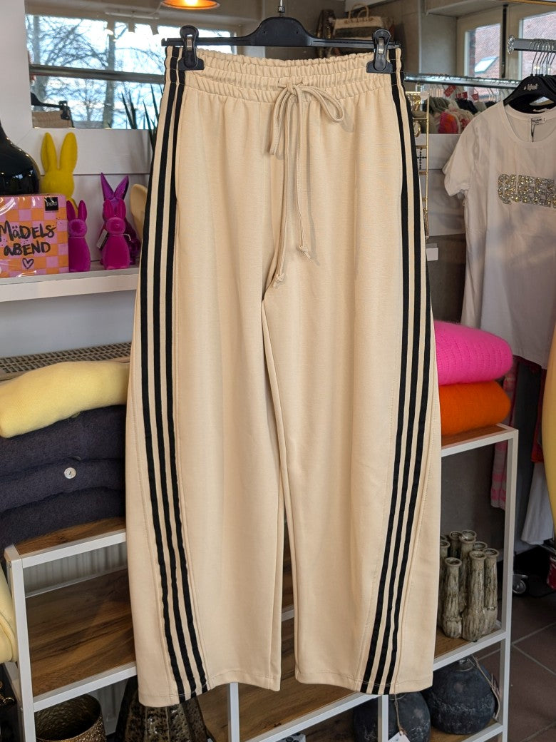Erlebe Komfort und Style mit der trendigen Jogginghose von LUMINA in Créme mit den markanten dynamischen drei Streifen in Schwarz - für entspannte Tage!