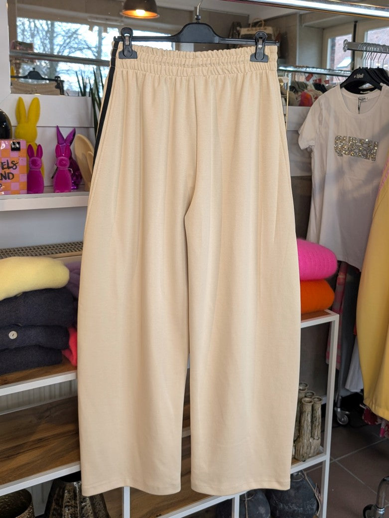 Erlebe Komfort und Style mit der trendigen Jogginghose von LUMINA in Créme mit den markanten dynamischen drei Streifen in Schwarz - für entspannte Tage!