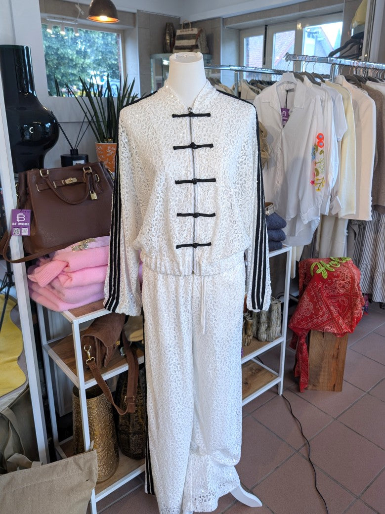 Exklusive Hose von LUMINA mit raffinierten feinen Spitzen- und Pailletten-Details, veredelt durch 3 schwarze Streifen. Statement-Piece für selbstbewusste Looks!