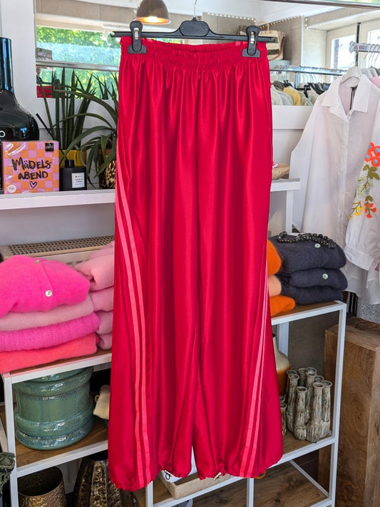 Komfort und Style mit der trendigen Jogginghose von CHANCE OFF in glänzend leuchtendem Rot mit dynamischen Streifen in Pink - für entspannte Tage!