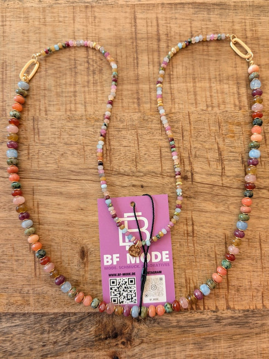 Diese auffällige XL-Kette aus bunten Steinen und Naturtönen misst 90 cm und bringt lebendige Farben in Ihre Garderobe. Unterstreiche Deine individuelle Note!