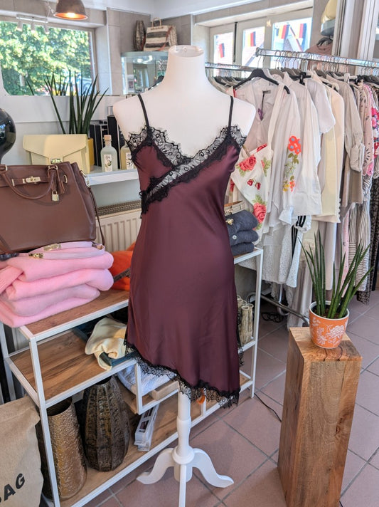 Das asymmetrische Kleid aus seidenmattem Satin kombiniert Rot mit schwarzer Spitze und weichem Innenfutter für höchsten Tragekomfort - wirkt ideal über Jeans!
