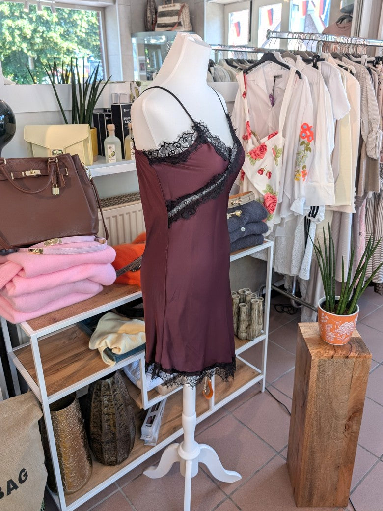 Das asymmetrische Kleid aus seidenmattem Satin kombiniert Rot mit schwarzer Spitze und weichem Innenfutter für höchsten Tragekomfort - wirkt ideal über Jeans!