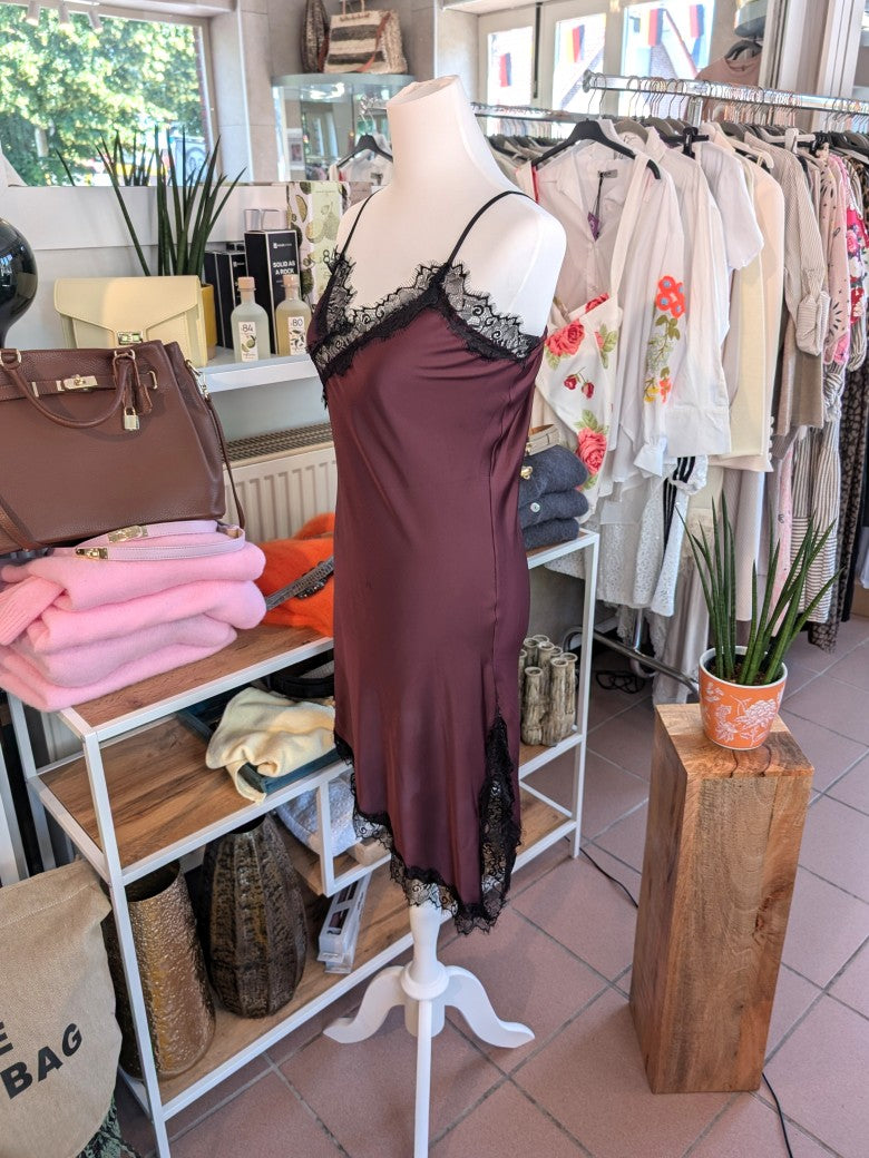 Das asymmetrische Kleid aus seidenmattem Satin kombiniert Rot mit schwarzer Spitze und weichem Innenfutter für höchsten Tragekomfort - wirkt ideal über Jeans!