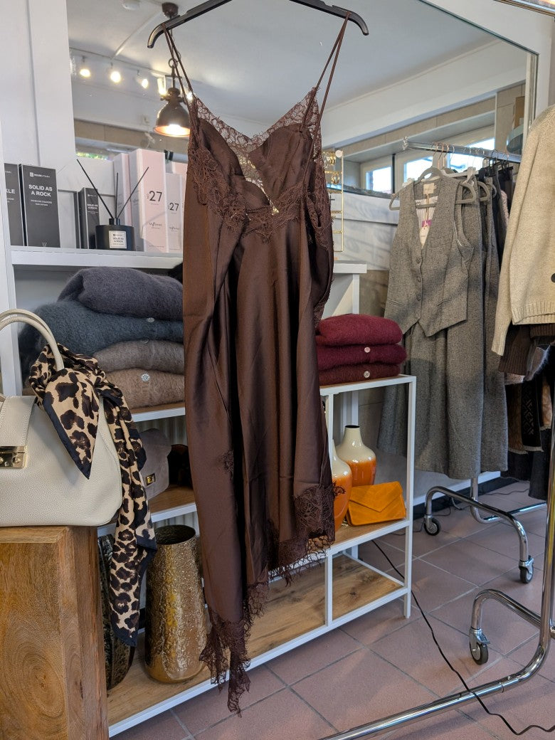 Das asymmetrische Kleid aus seidenmattem Satin in Coffee Braun kombiniert zarte Spitze und weiches Innenfutter für höchsten Tragekomfort- wirkt ideal über Jeans!