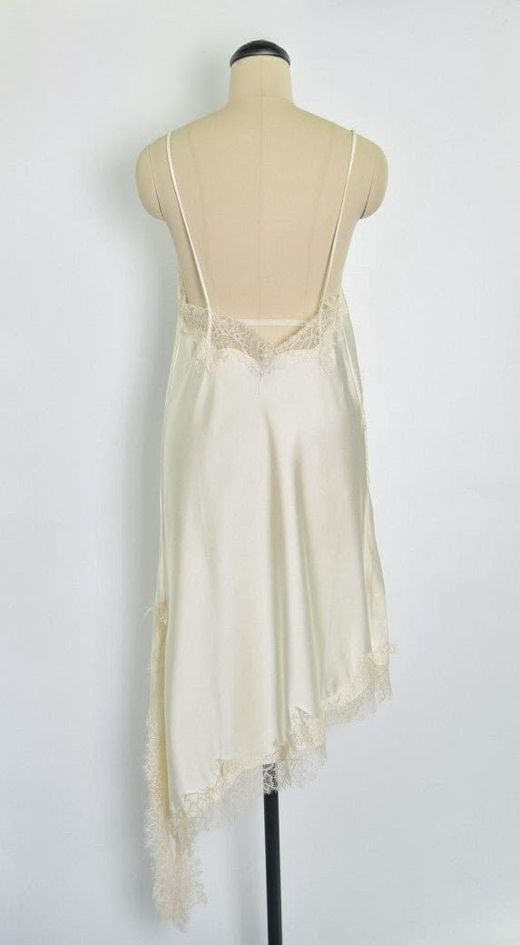 Das asymmetrische Kleid aus seidenmattem Satin in Creme kombiniert zarte Spitze und weiches Innenfutter für höchsten Tragekomfort - wirkt ideal über Jeans/Pants!