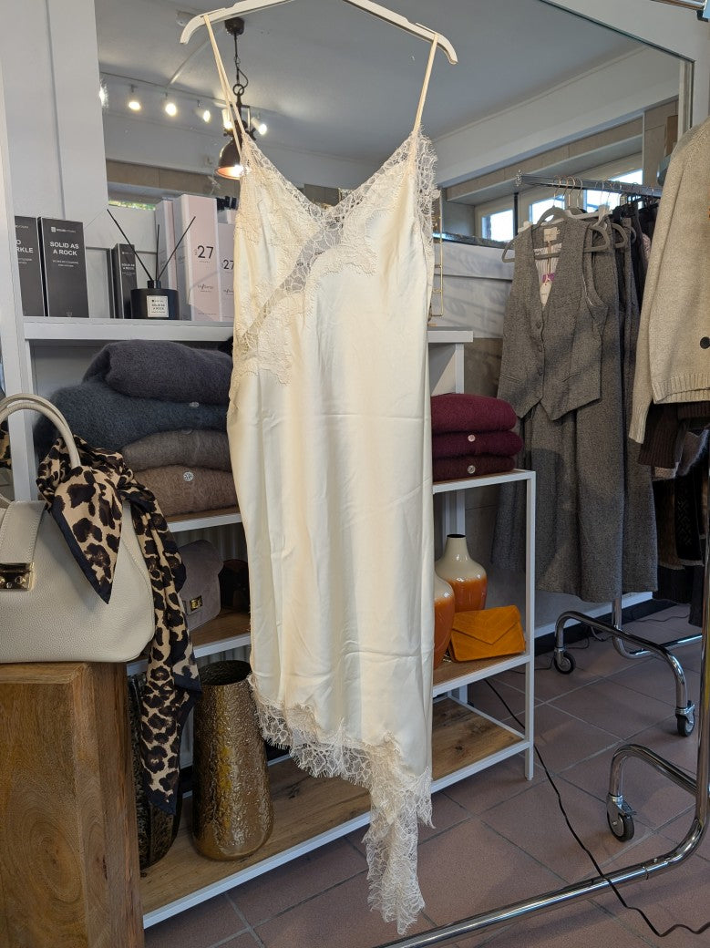 Das asymmetrische Kleid aus seidenmattem Satin in Creme kombiniert zarte Spitze und weiches Innenfutter für höchsten Tragekomfort - wirkt ideal über Jeans/Pants!