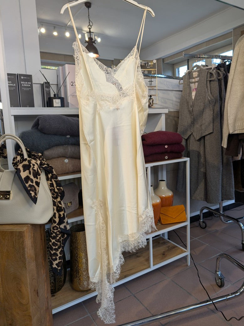 Das asymmetrische Kleid aus seidenmattem Satin in Creme kombiniert zarte Spitze und weiches Innenfutter für höchsten Tragekomfort - wirkt ideal über Jeans/Pants!