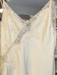 Das asymmetrische Kleid aus seidenmattem Satin in Creme kombiniert zarte Spitze und weiches Innenfutter für höchsten Tragekomfort - wirkt ideal über Jeans/Pants!