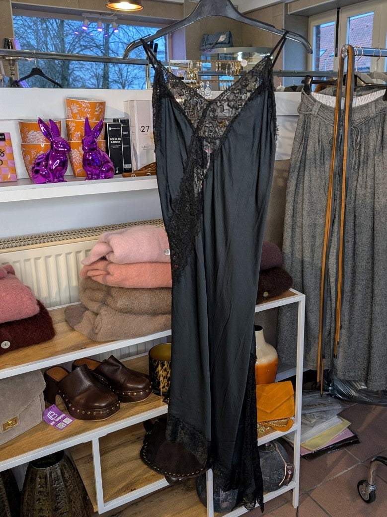 Das asymmetrische Kleid aus seidenmattem Satin kombiniert Schwarz mit schwarzer Spitze und weichem Innenfutter für höchsten Tragekomfort - wirkt ideal über Jeans!