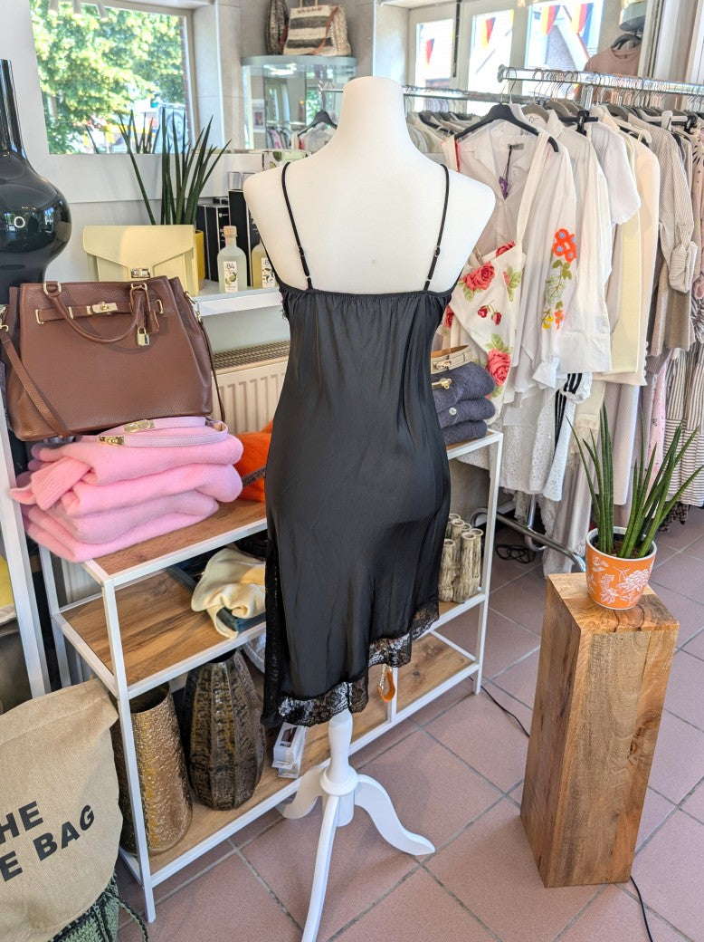 Das asymmetrische Kleid aus seidenmattem Satin kombiniert Schwarz mit schwarzer Spitze und weichem Innenfutter für höchsten Tragekomfort - wirkt ideal über Jeans!
