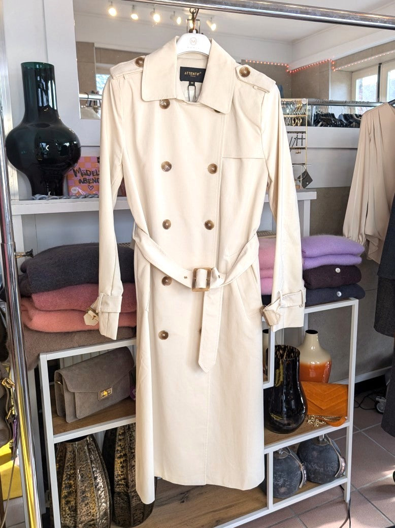 Der lange doppelreihige Trenchcoat Mantel in Creme aus Baumwolle von ATTENTIF kombiniert stilvollen Schnitt und zeitlose Eleganz für anspruchsvolle Damenmode.