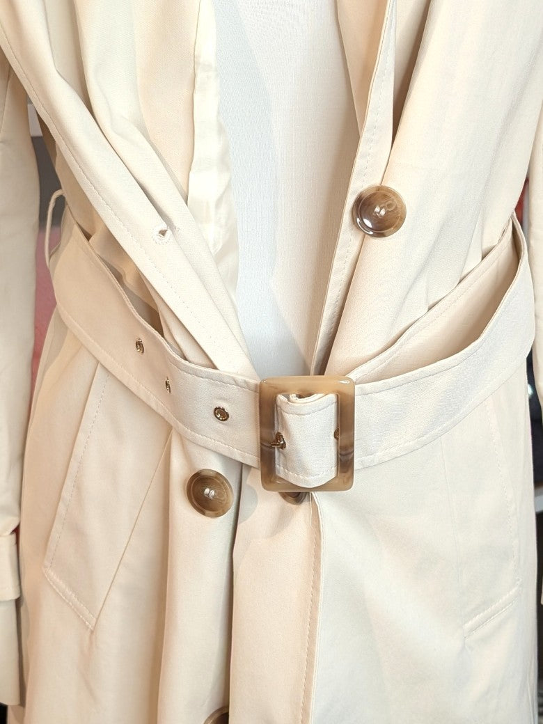 Der lange doppelreihige Trenchcoat Mantel in Creme aus Baumwolle von ATTENTIF kombiniert stilvollen Schnitt und zeitlose Eleganz für anspruchsvolle Damenmode.