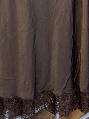 Verleihe deinem Outfit einen Hauch von Eleganz mit diesem langen Satin Rock aus Viskose in Coffee Braun mit brauner Spitze. Perfekt für das gewisse Etwas!