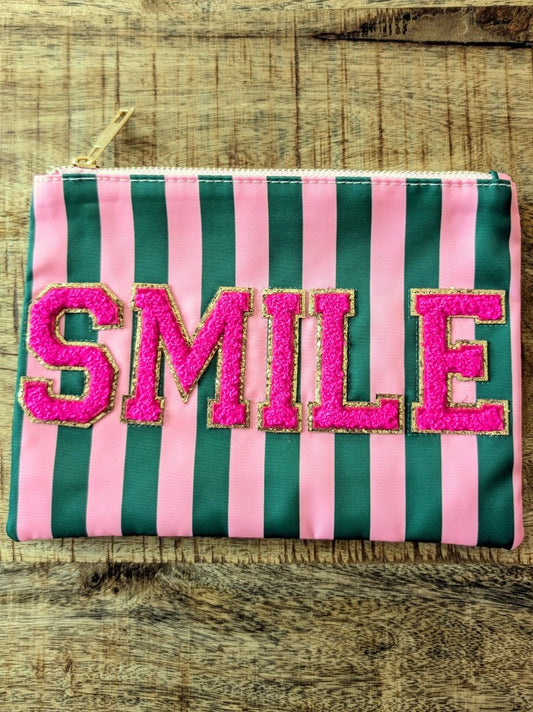Die Make-Up- und Kosmetiktasche vereint praktische Funktionalität mit fröhlichem Design in gestreiftem Muster Rosa Pink Grün mit "SMILE" in Pink mit Goldrand!