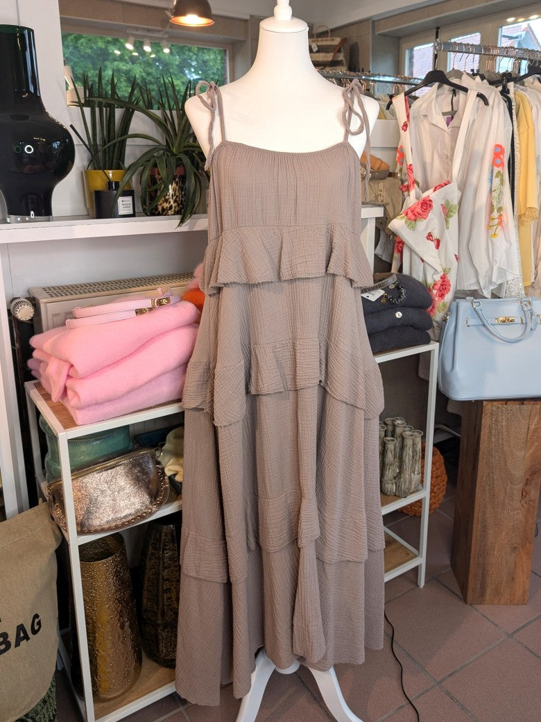 Das elegante zeitlose feminine Maxi-Kleid in Taupe aus luftigem Mousselin verzaubert mit verspielten Volants und zarten Trägern. Perfekt für sommerliche Anlässe!