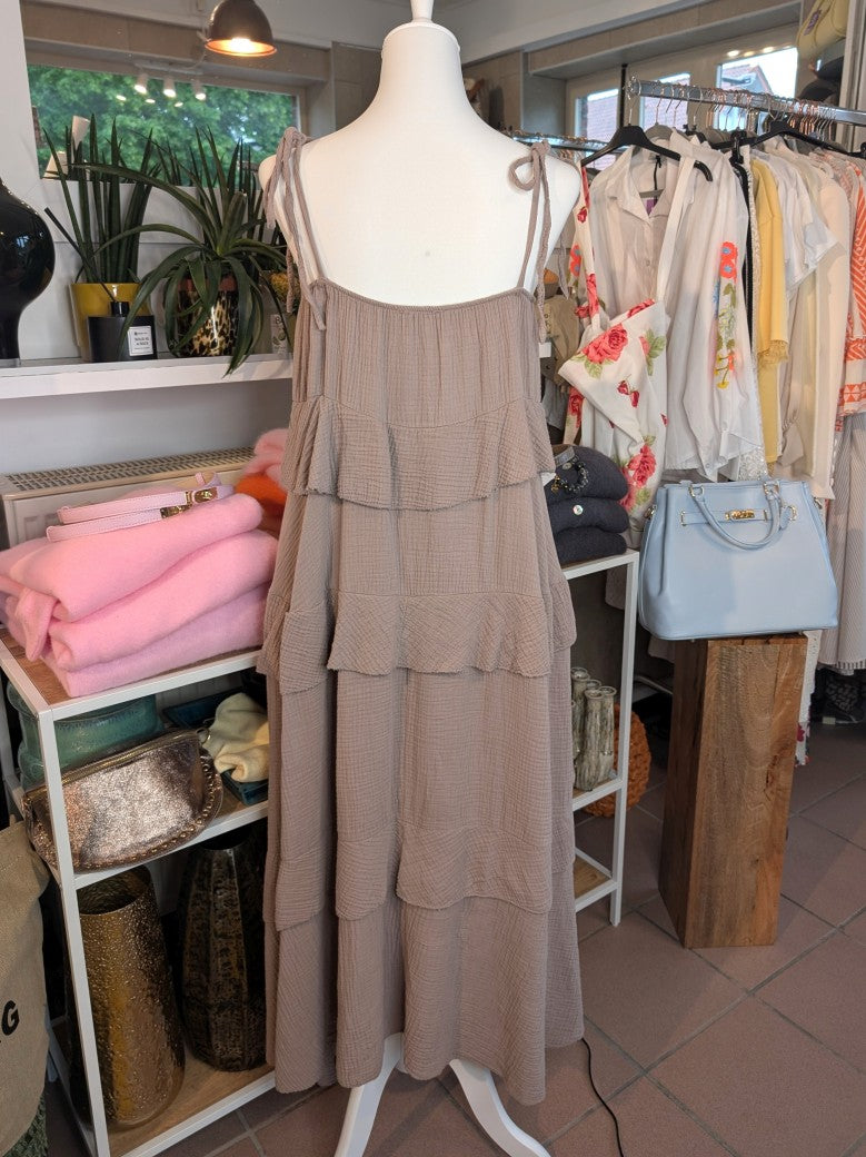 Das elegante zeitlose feminine Maxi-Kleid in Taupe aus luftigem Mousselin verzaubert mit verspielten Volants und zarten Trägern. Perfekt für sommerliche Anlässe!