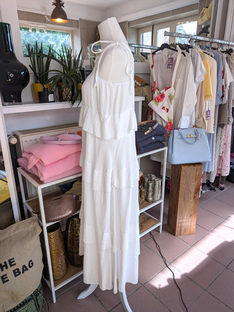 Das elegante zeitlose weiße feminine Maxi-Kleid aus luftigem Mousselin verzaubert mit verspielten Volants und zarten Trägern. Perfekt für sommerliche Anlässe!