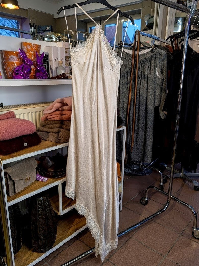 Das asymmetrische Kleid aus seidenmattem Viskose Satin in Champagner Beige mit heller Spitze wirkt ideal über Pants und Jeans - femininer absoluter Hingucker!