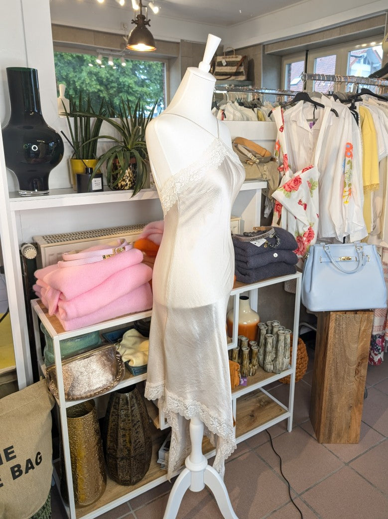 Das asymmetrische Kleid aus seidenmattem Viskose Satin in Champagner Beige mit heller Spitze wirkt ideal über Pants und Jeans - femininer absoluter Hingucker!
