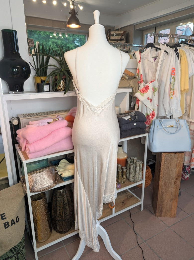 Das asymmetrische Kleid aus seidenmattem Viskose Satin in Champagner Beige mit heller Spitze wirkt ideal über Pants und Jeans - femininer absoluter Hingucker!