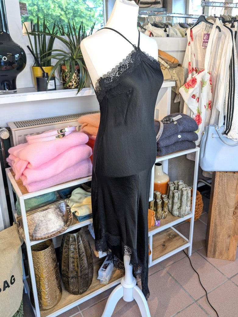 Das asymmetrische Kleid aus seidenmattem Viskose Satin in Schwarz mit schwarzer Spitze wirkt ideal über Pants und Jeans - femininer absoluter Hingucker!