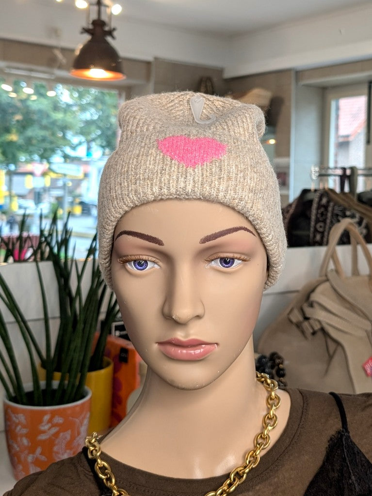 Kuschelige Wintermütze mit Umschlag aus weicher Viskose-Woll-Mischung in warmem Beige mit charmanten Herz Akzent in Pink wärmt stilvoll an kalten Tagen.