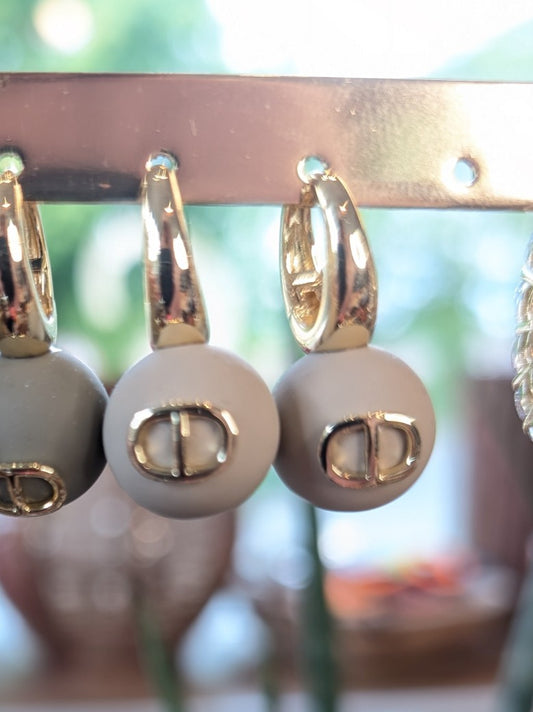 Die eleganten Ohrringe im Dior-Stil mit Perlen in Beige mit Goldfinish verbinden Luxus mit Vielseitigkeit. Perfekt für alltägliche Eleganz und besondere Anlässe.