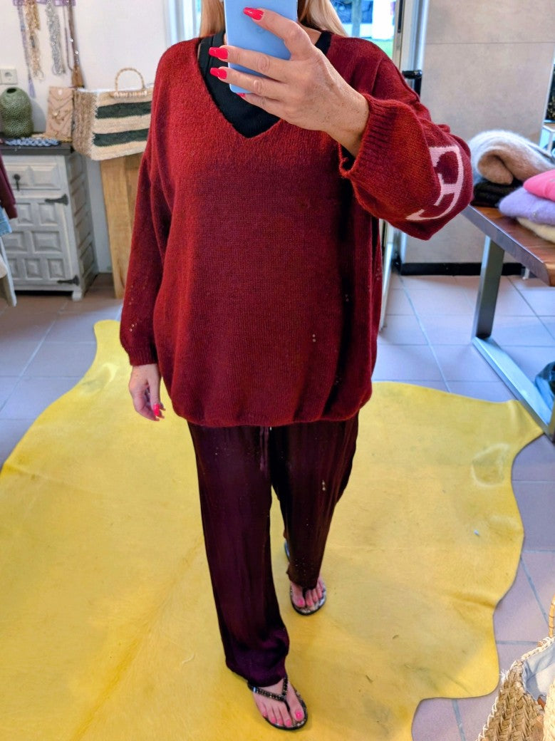 Der Pullover Namaste von BELIEVE besticht durch seinen eleganten V-Ausschnitt und den auffälligen Backprint in den Trendfarben Burgunder/Brombeere und Rosa.