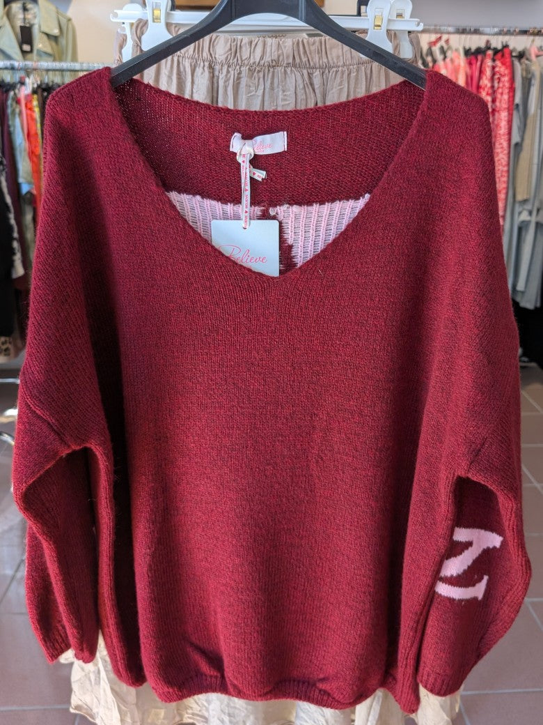 Der Pullover Namaste von BELIEVE besticht durch seinen eleganten V-Ausschnitt und den auffälligen Backprint in den Trendfarben Burgunder/Brombeere und Rosa.