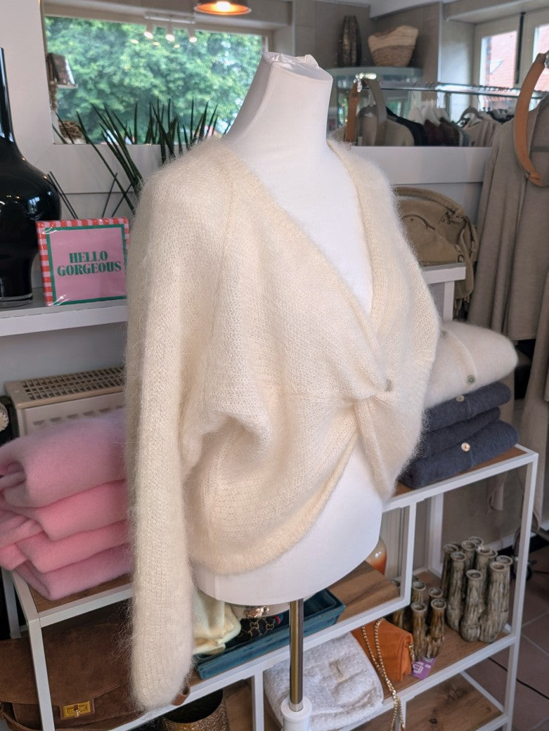 Der weiche Mohair-Pullover aus 80% Kid Mohair Créme mit V-Ausschnitt verbindet flauschigen Komfort mit eleganten Knotendesign - perfekt für kühlere Tage!