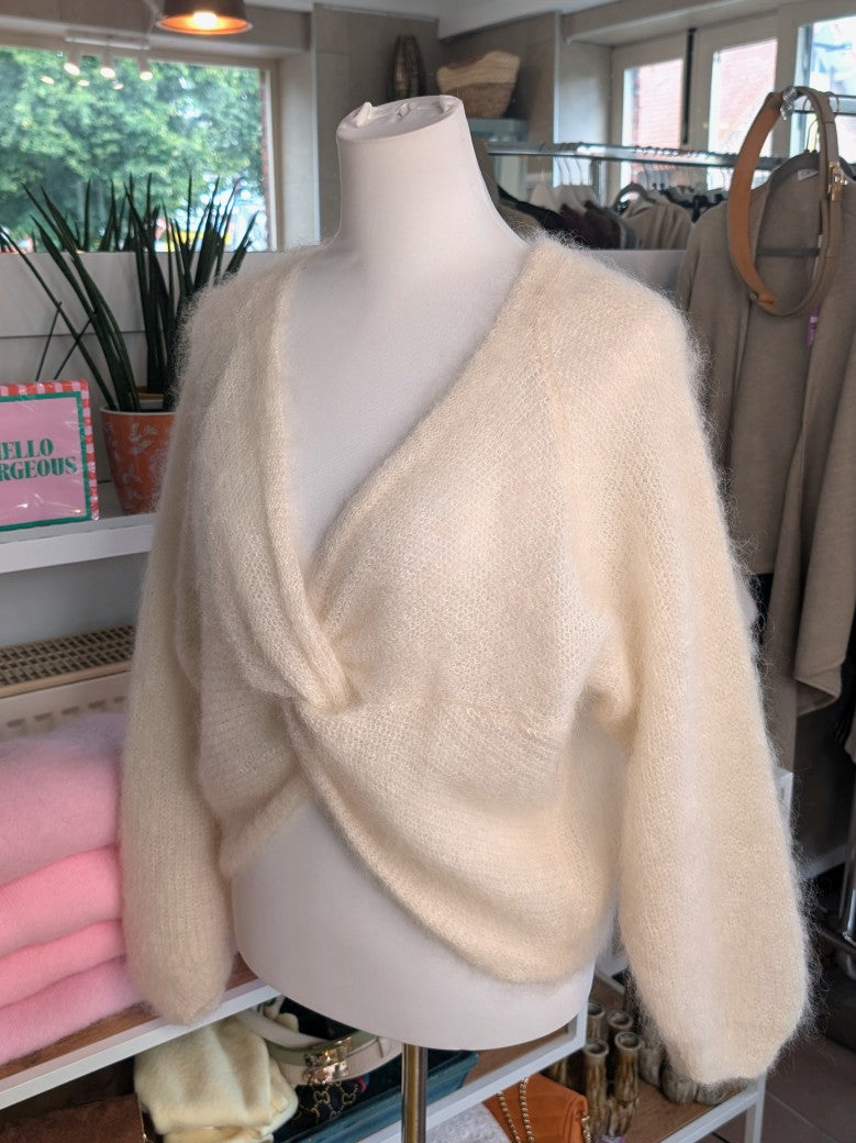Der weiche Mohair-Pullover aus 80% Kid Mohair Créme mit V-Ausschnitt verbindet flauschigen Komfort mit eleganten Knotendesign - perfekt für kühlere Tage!