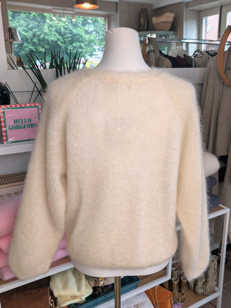 Der weiche Mohair-Pullover aus 80% Kid Mohair Créme mit V-Ausschnitt verbindet flauschigen Komfort mit eleganten Knotendesign - perfekt für kühlere Tage!