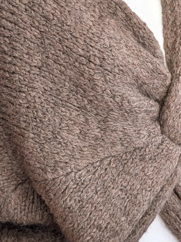Der weiche Pullover aus Wolle-Viskose-Mischung Taupe mit V-Ausschnitt verbindet flauschigen Komfort mit eleganten Knotendesign - perfekt für kühlere Tage!