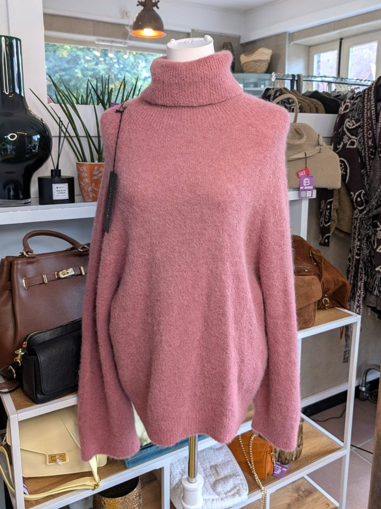 Der luxuriös samtweiche rosa Rollkragenpullover verbindet zeitlose Eleganz mit unvergleichlichem Tragekomfort – perfekt für gemütliche Herbst- und Wintertage!