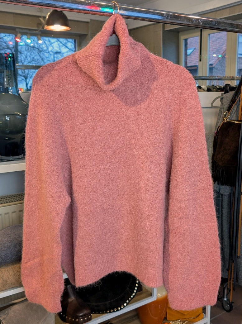Der luxuriös samtweiche rosa Rollkragenpullover verbindet zeitlose Eleganz mit unvergleichlichem Tragekomfort – perfekt für gemütliche Herbst- und Wintertage!