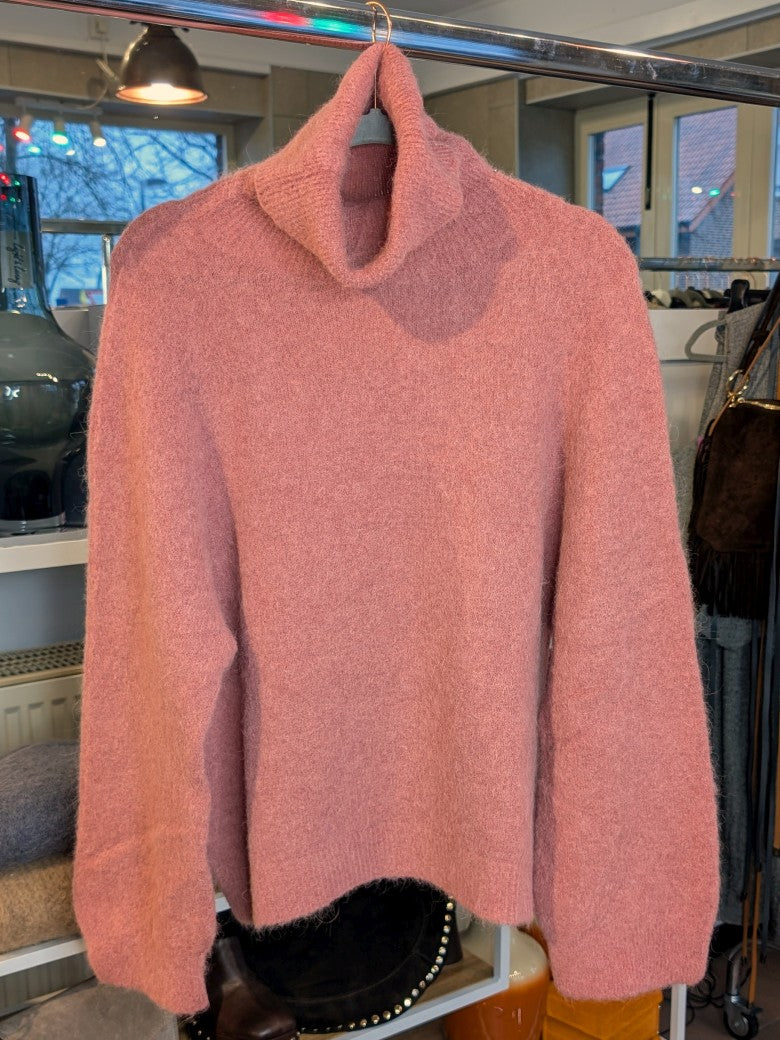 Der luxuriös samtweiche rosa Rollkragenpullover verbindet zeitlose Eleganz mit unvergleichlichem Tragekomfort – perfekt für gemütliche Herbst- und Wintertage!