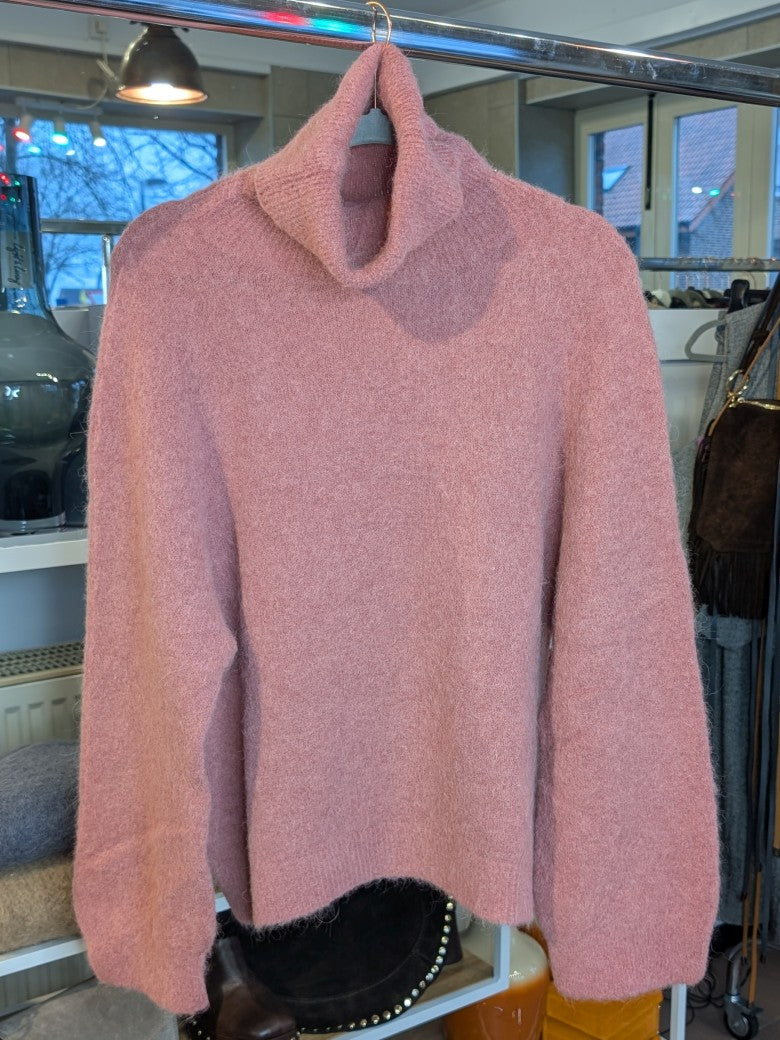 Der luxuriös samtweiche rosa Rollkragenpullover verbindet zeitlose Eleganz mit unvergleichlichem Tragekomfort – perfekt für gemütliche Herbst- und Wintertage!