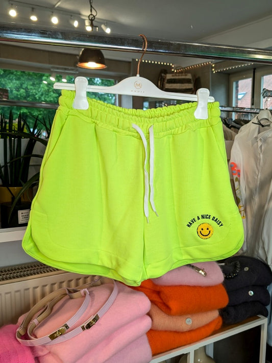 Entdecke den perfekten Sommerlook mit unser "Have A Nice Day" Smiley Shorts in Neon Gelb aus bequemem Sweatshirtstoff. Ideal und auffallend für heiße Tage!