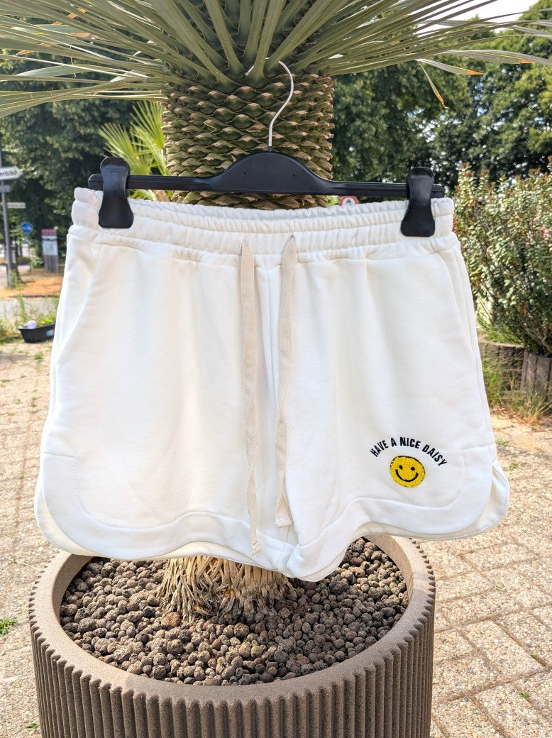 Entdecke den perfekten Sommerlook mit unser "Have A Nice Day" Smiley Shorts in Weiß aus bequemem Sweatshirtstoff. Ideal und auffallend für heiße Tage!