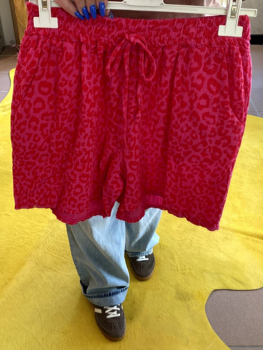 Entdecken Sie unsere stylische luftige Mousselin-Shorts im angesagten Leo-Muster in Pink und Rot – ein Must-Have für modebewusste Frauen.