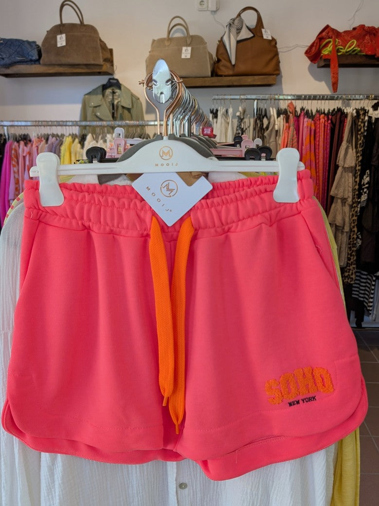 Erwecke den Sommer mit dieser stylischen SOHO Shorts aus Sweatshirtstoff in Neon Pink mit Schriftzug in Neon Orange aus Baumwolle. Perfekt für jeden Anlass!