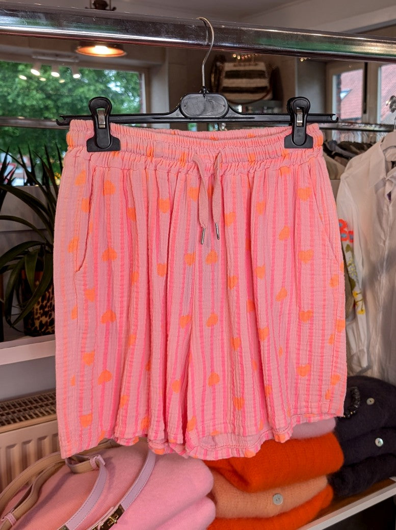 Entdecken Sie unsere stylische luftige Mousselin-Shorts mit angesagten Streifen in Rosa Pink mit orangen Herzen – ein Must-Have für modebewusste Frauen.