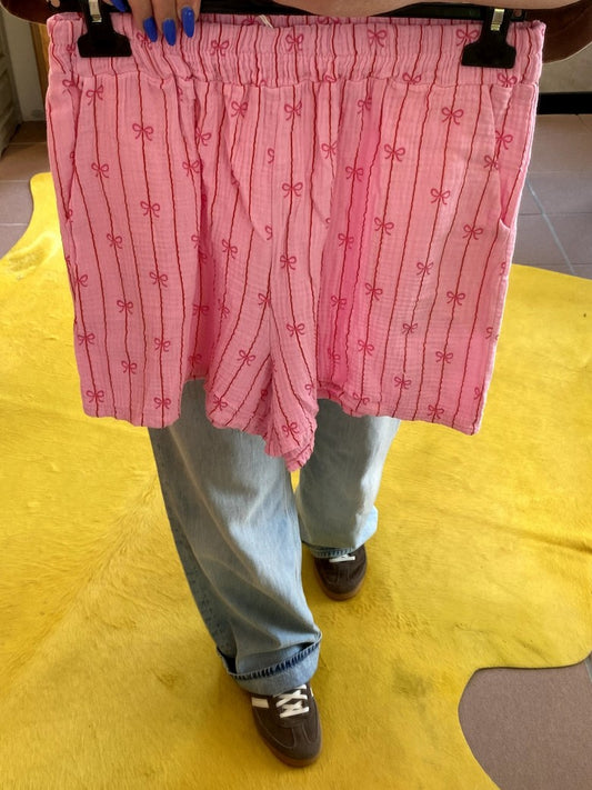 Entdecken Sie unsere stylische luftige Mousselin-Shorts mit angesagten Streifen in Rosa Pink mit pinken Schleifen – ein Must-Have für modebewusste Frauen.